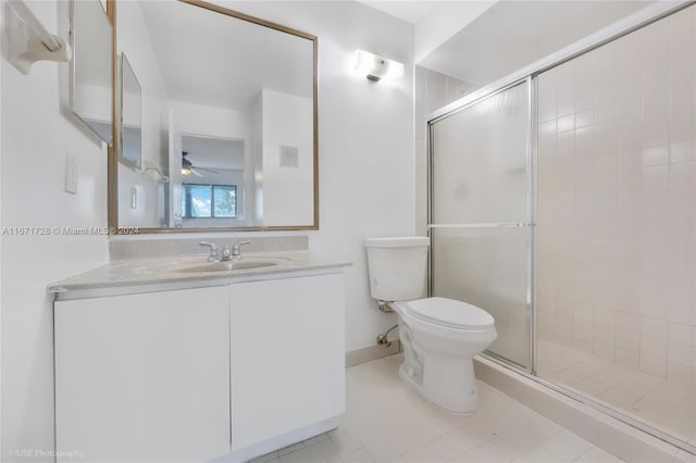 bathroom with toilet, vanity, tile patterned flooring, and a shower with door