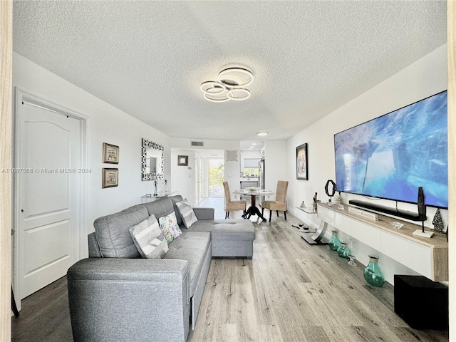 living room featuring a textured ceiling and light hardwood / wood-style flooring