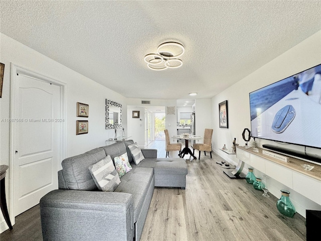 living room with light hardwood / wood-style flooring and a textured ceiling