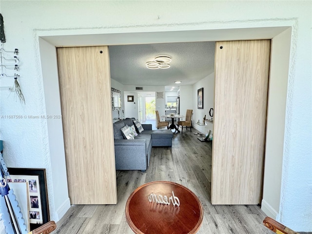 hallway with a textured ceiling and hardwood / wood-style flooring