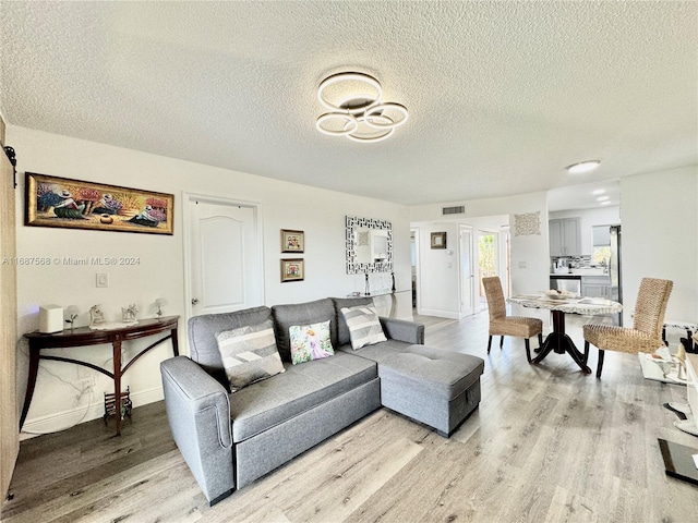 living room featuring a textured ceiling and light hardwood / wood-style floors