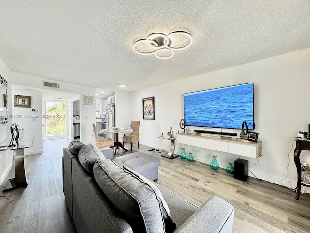 living room with light hardwood / wood-style floors and a textured ceiling