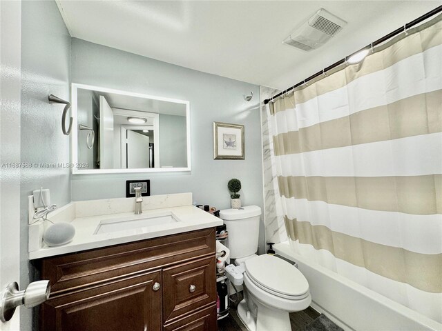 full bathroom featuring vanity, shower / tub combo, and toilet