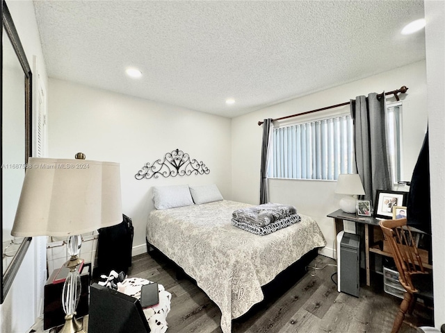 bedroom with a textured ceiling and dark hardwood / wood-style flooring