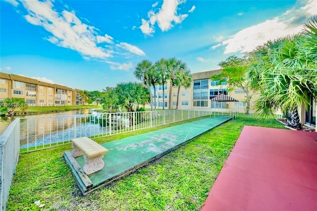 view of property's community with a yard and a water view