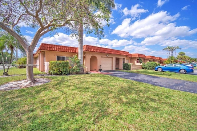 mediterranean / spanish home featuring a front lawn and a garage