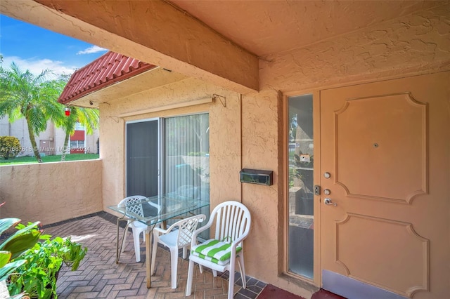 view of exterior entry with a patio