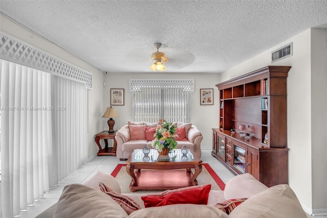 tiled living room with a textured ceiling and ceiling fan