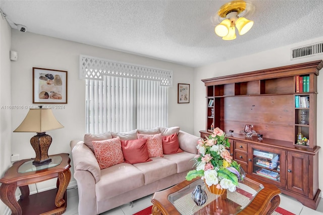 living room with a textured ceiling and light tile patterned floors