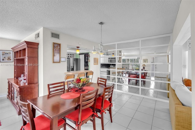 dining area featuring light tile patterned flooring, ceiling fan, and a textured ceiling