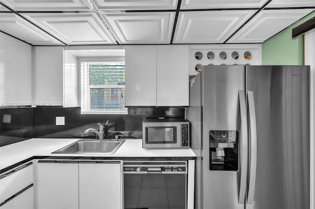 kitchen featuring white cabinetry, stainless steel appliances, sink, and tasteful backsplash