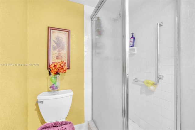 bathroom with toilet and a shower with shower door