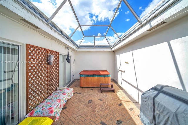 view of patio with a hot tub and a lanai