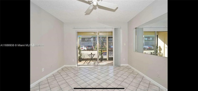 tiled empty room with ceiling fan, a healthy amount of sunlight, and a textured ceiling