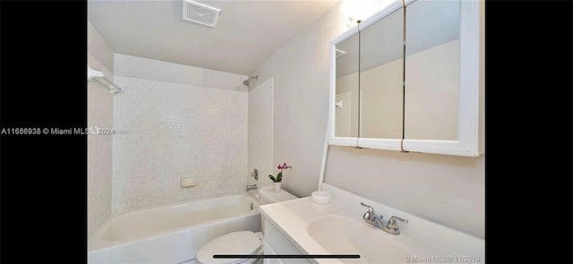 full bathroom with vanity, tiled shower / bath combo, and toilet