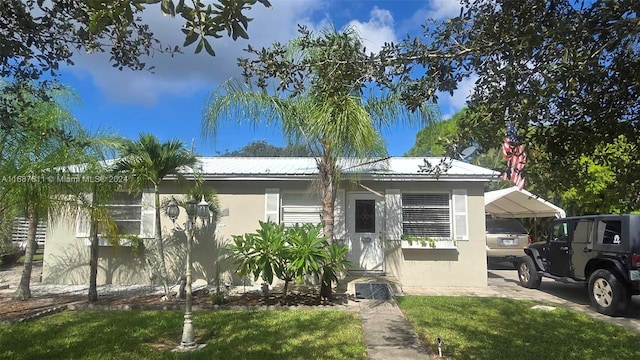 view of front of home featuring a carport and a front lawn