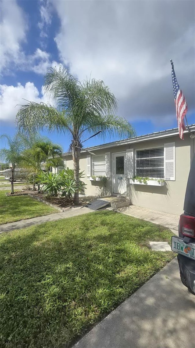 view of front facade featuring a front yard and stucco siding