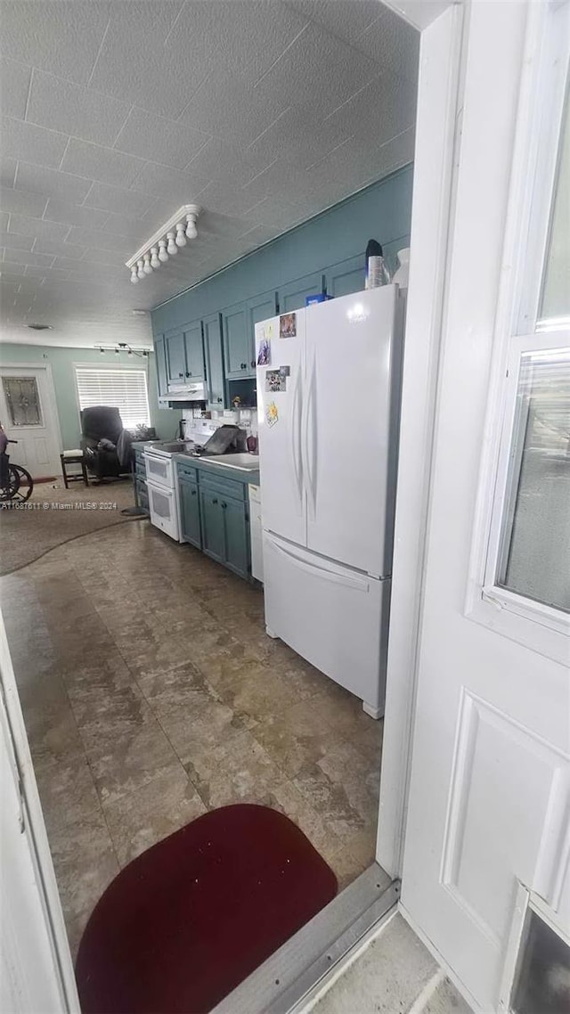 kitchen with white appliances and blue cabinets