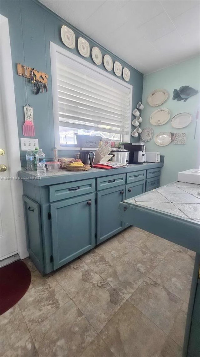 kitchen featuring healthy amount of natural light and blue cabinets
