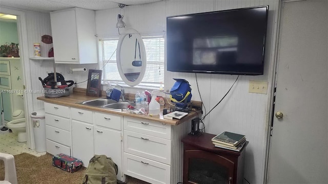 kitchen with a sink, white cabinets, and open shelves