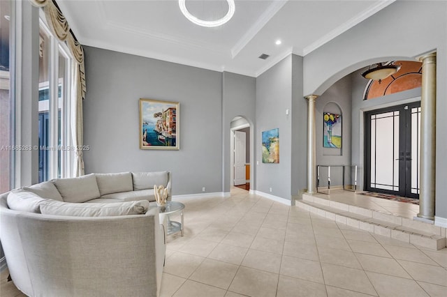 tiled living room featuring crown molding and ornate columns