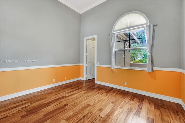 spare room with lofted ceiling and light hardwood / wood-style flooring