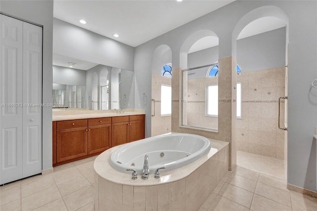 bathroom featuring tile patterned flooring, shower with separate bathtub, and vanity