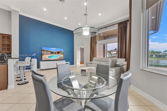 tiled dining space featuring ornamental molding and plenty of natural light