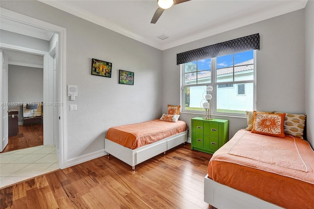 bedroom with ornamental molding, ceiling fan, and light hardwood / wood-style floors