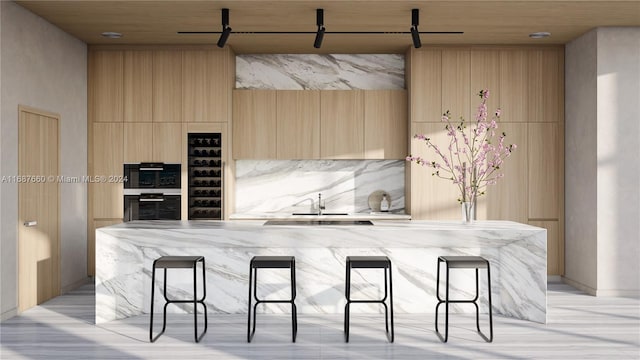 kitchen with sink, a kitchen breakfast bar, light brown cabinets, and decorative backsplash