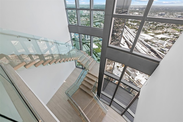 stairs featuring a high ceiling and wood-type flooring