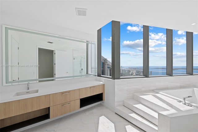 bathroom with vanity, tile walls, shower with separate bathtub, and a water view