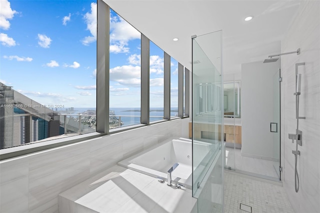 bathroom featuring shower with separate bathtub, a water view, and tile patterned flooring