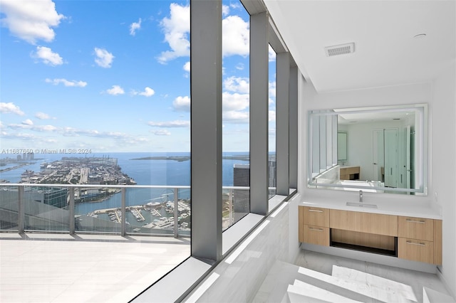 balcony featuring sink and a water view