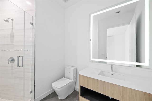 bathroom featuring a shower with door, vanity, toilet, and tile patterned flooring