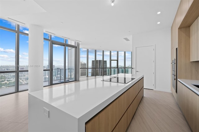 kitchen with a spacious island, black electric cooktop, and plenty of natural light