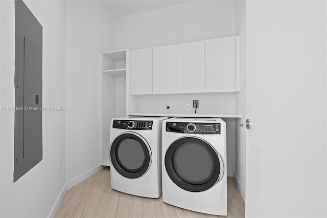 washroom featuring light hardwood / wood-style floors, electric panel, cabinets, and separate washer and dryer