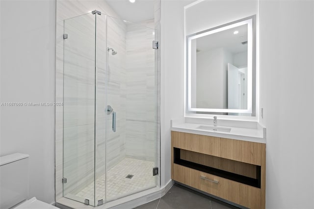 bathroom with toilet, a shower with shower door, and vanity