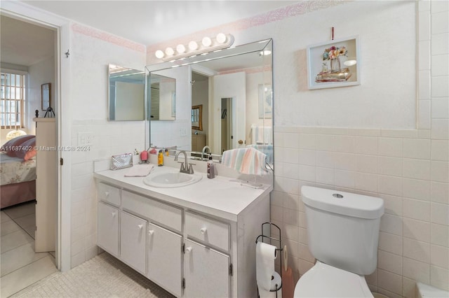1333 E Hallandale Beach Blvd Unit 409, Hallandale Beach, FL 33009 - ensuite bathroom with tile walls, tile patterned floors, vanity, and wainscoting