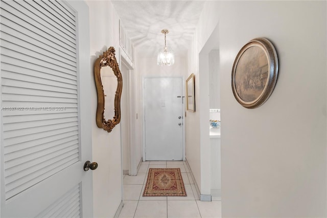 entryway featuring light tile patterned floors and an inviting chandelier