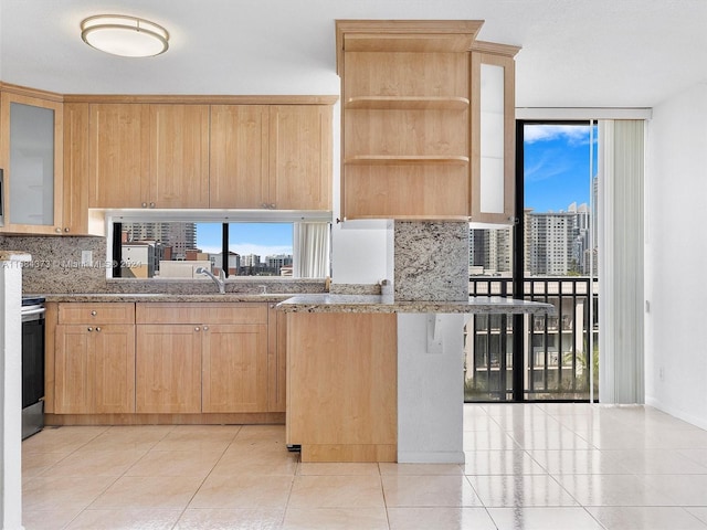 17021 N Bay Rd Unit 701, Sunny Isles Beach, FL 33160 - kitchen featuring backsplash, light brown cabinets, a view of city, light tile patterned floors, and glass insert cabinets