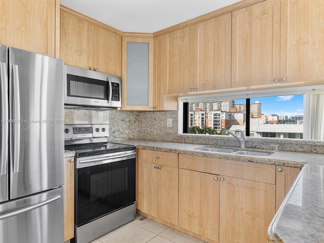 kitchen featuring appliances with stainless steel finishes, sink, decorative backsplash, light tile patterned floors, and light brown cabinets