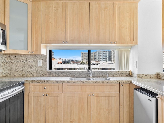 kitchen with sink, light brown cabinets, and stainless steel appliances