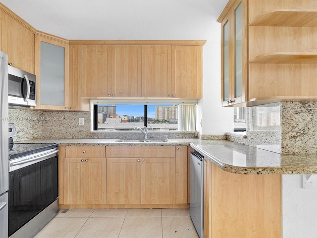 kitchen with light stone countertops, sink, stainless steel appliances, light tile patterned floors, and light brown cabinets