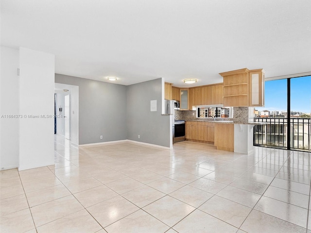 kitchen with tasteful backsplash, light tile patterned flooring, kitchen peninsula, a kitchen breakfast bar, and stainless steel stove