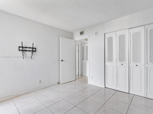 17021 N Bay Rd Unit 701, Sunny Isles Beach, FL 33160 - unfurnished bedroom with a textured ceiling, light tile patterned floors, and a closet