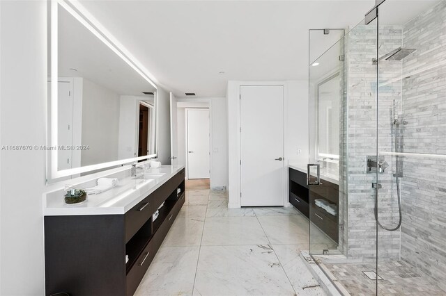 bathroom featuring a shower with door and vanity