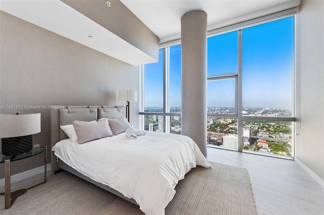 bedroom featuring expansive windows, multiple windows, and light hardwood / wood-style floors