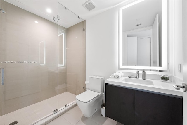 bathroom featuring toilet, a shower with shower door, vanity, and tile patterned floors