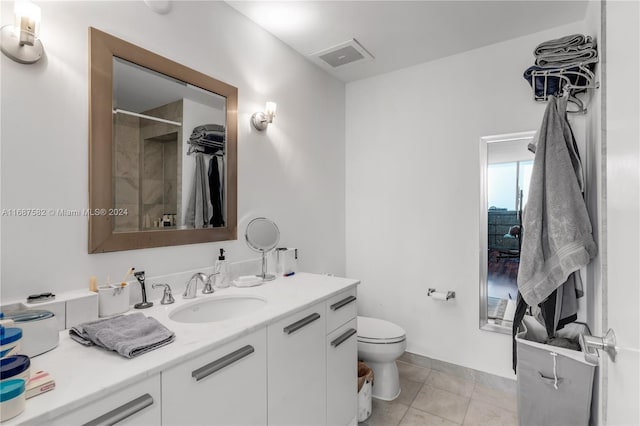 bathroom featuring vanity, toilet, tile patterned floors, and a shower